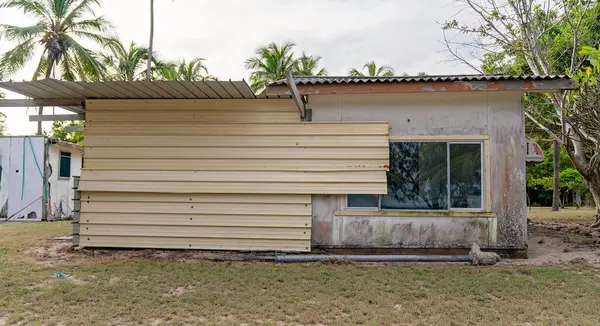 Yıpranmış sahil kulübesi yan onarımları gösteriyor.