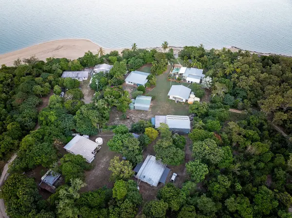 Teneke çatılı evleri, kumlu plajı ve yoğun tropikal yeşilliği olan bir yerleşim yeri..
