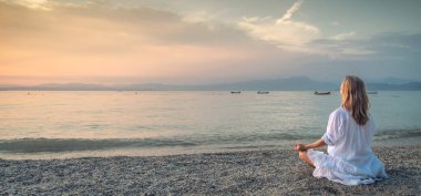 Garda Gölü 'nde meditasyon yapan kadın. Yoga pratiği. Gün batımı. İtalya