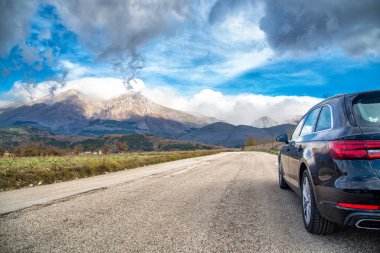 Dağ yolunda seyahat etmek için bir araba. Mavi gökyüzü