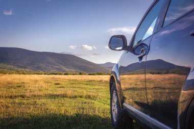 Dağ yolunda seyahat etmek için bir araba. Mavi gökyüzü