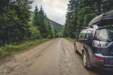 Dağ yolunda seyahat etmek için bir araba. Mavi gökyüzü