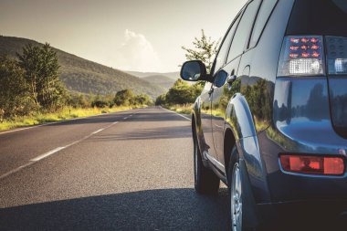 Dağ yolunda seyahat etmek için bir araba. Mavi gökyüzü