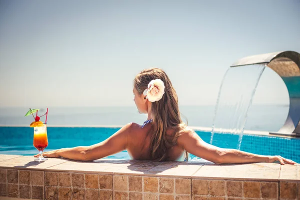 女人放松与鸡尾酒游泳池 — 图库照片