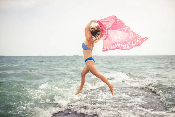 快乐美丽的小女孩在大海里跳跃 日落时分 — 图库照片