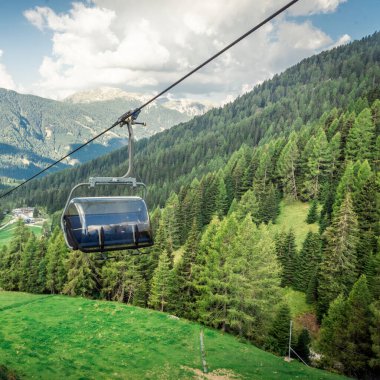 Dağ kayak merkezinde teleferik, yeşil orman. Alpler. İtalya