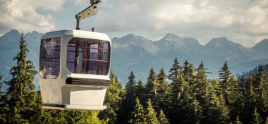 gondola ski lift in mountain ski resort, green forest. Alps. Italy