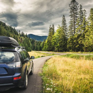 Dağ yolunda seyahat etmek için bir araba. Mavi gökyüzü