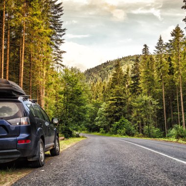 Dağ yolunda seyahat etmek için bir araba. Mavi gökyüzü