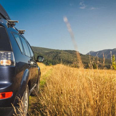 Dağ yolunda seyahat etmek için bir araba. Mavi gökyüzü