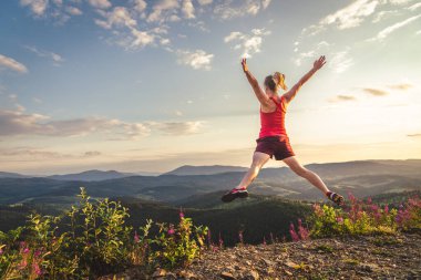 Genç kadın dağlar üstüne atlama