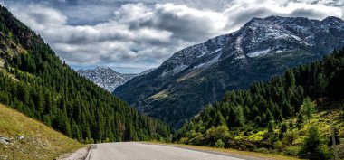 Kırsal yol, bulutlar ve kar dağı. Avusturya