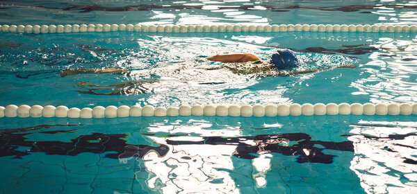 Woman swimming with swimming hat and swimsuit in swimming pool