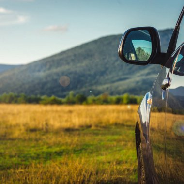 Dağ yolunda seyahat etmek için bir araba. Mavi gökyüzü