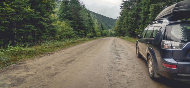 Dağ yolunda seyahat etmek için bir araba. Mavi gökyüzü