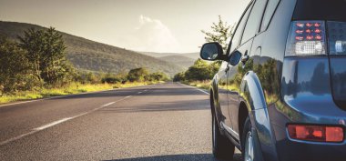 Dağ yolunda seyahat etmek için bir araba. Mavi gökyüzü