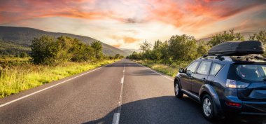 car for traveling with a mountain road. Dramatic sky