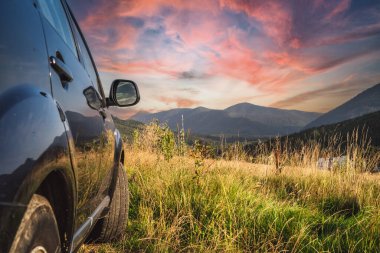 car for traveling with a mountain road. Dramatic sky