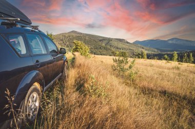 car for traveling with a mountain road. Dramatic sky