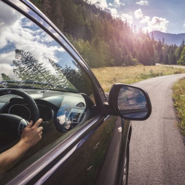 Dağ yolunda seyahat etmek için bir araba. Mavi gökyüzü