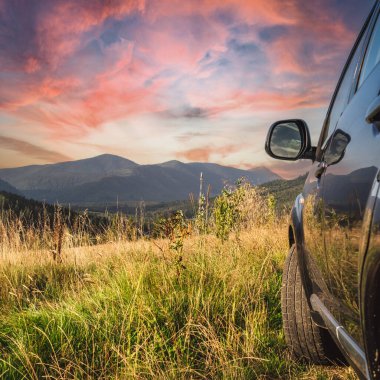 car for traveling with a mountain road. Dramatic sky