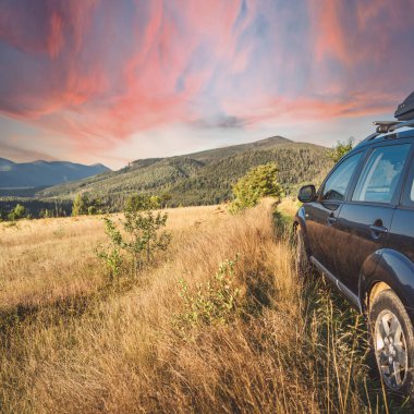 car for traveling with a mountain road. Dramatic sky