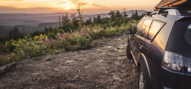 car for traveling with a mountain road. Dramatic sky