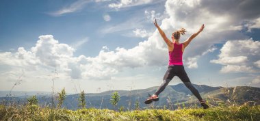 Genç kadın dağlar üstüne atlama