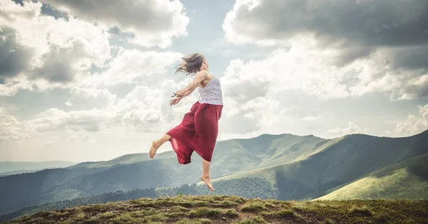 stock image Young woman jumping on the top of mountains