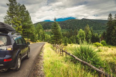 Woman in white bathrobe lying on sofa and relaxing with orange cocktail at the roof of hotel
