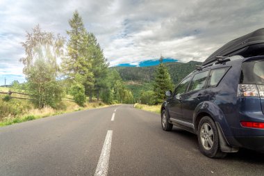 Woman in white bathrobe lying on sofa and relaxing with orange cocktail at the roof of hotel