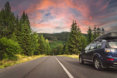 Woman in white bathrobe lying on sofa and relaxing with orange cocktail at the roof of hotel