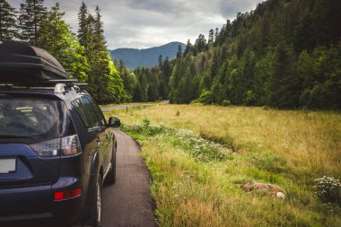 Woman in white bathrobe lying on sofa and relaxing with orange cocktail at the roof of hotel