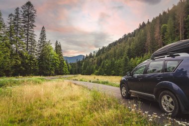 Woman in white bathrobe lying on sofa and relaxing with orange cocktail at the roof of hotel