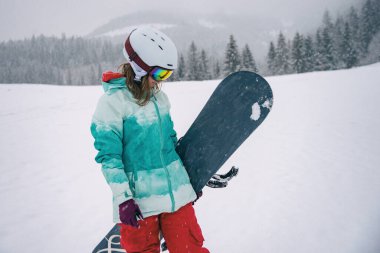 dağlarda at binme snowboard üzerinde genç ve güzel kadın