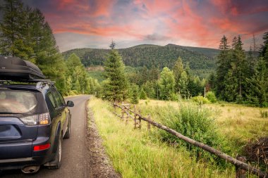 car for traveling with a mountain road. Dramatic sky