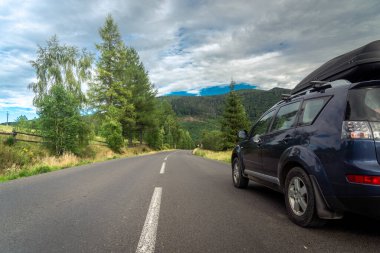 car for traveling with a mountain road. Dramatic sky