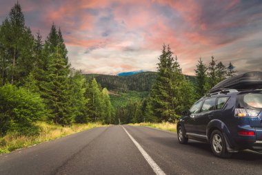 car for traveling with a mountain road. Dramatic sky