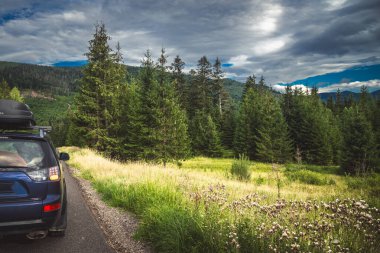 car for traveling with a mountain road. Dramatic sky