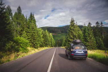 car for traveling with a mountain road. Dramatic sky