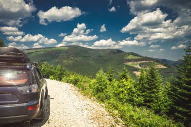 car for traveling with a mountain road. Dramatic sky
