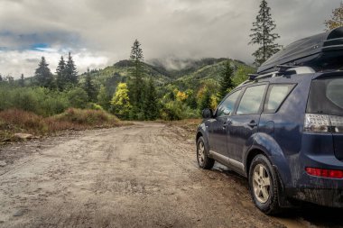 car for traveling with a mountain road. Dramatic sky