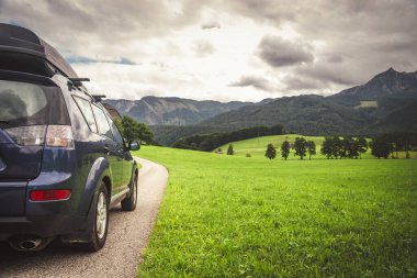 car for traveling with a mountain road. Dramatic sky