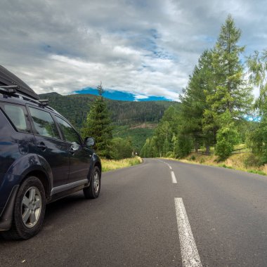 car for traveling with a mountain road. Dramatic sky