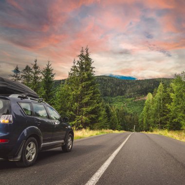 car for traveling with a mountain road. Dramatic sky