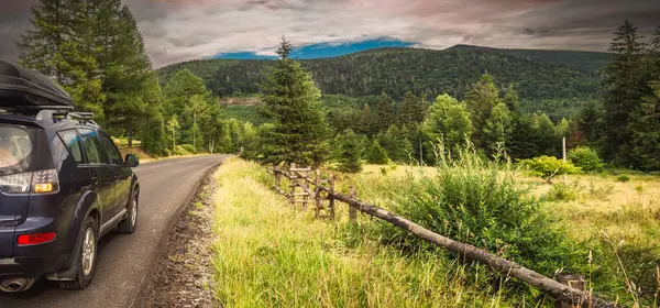 car for traveling with a mountain road. Dramatic sky