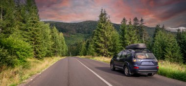 car for traveling with a mountain road. Dramatic sky