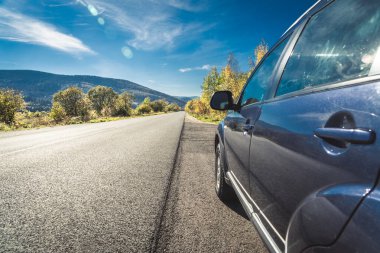 car for traveling with a mountain road. Dramatic sky