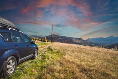 car for traveling with a mountain road. Dramatic sky