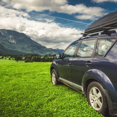car for traveling with a mountain road. Dramatic sky